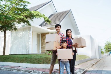 evinin önünde çocuk ayakta olan aile