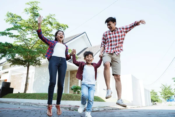 Eltern mit Kind genießen das gemeinsame Spielen vor ihrem neuen Haus — Stockfoto