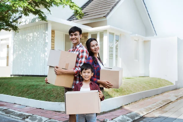 Family with kid standing in front of their house — Stock Photo, Image