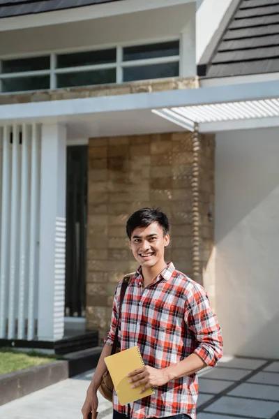 Άντρας μαθητής στέκεται μπροστά από το σπίτι του — Φωτογραφία Αρχείου