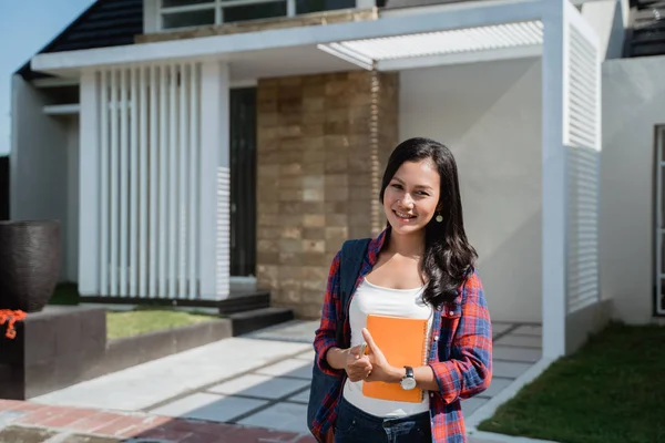 Femelle asiatique étudiant en face de son maison — Photo