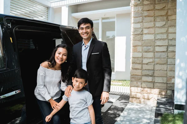 Parent avec enfant devant leur voiture souriant — Photo