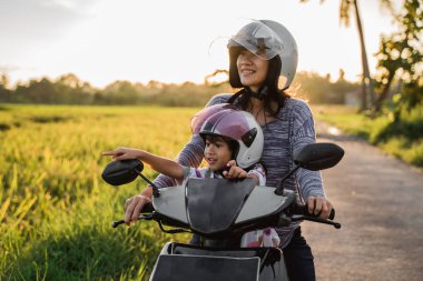 Anne ve çocuğu motosiklet scooter sürme zevk