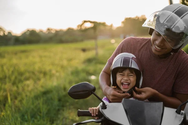 Baba kask tutturmak için kızı yardım — Stok fotoğraf