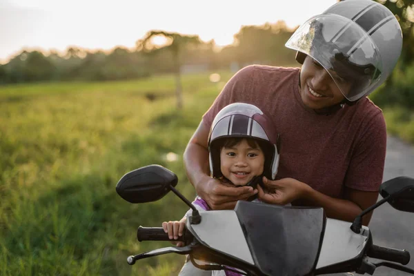 Papa hilft Tochter, den Helm zu befestigen — Stockfoto