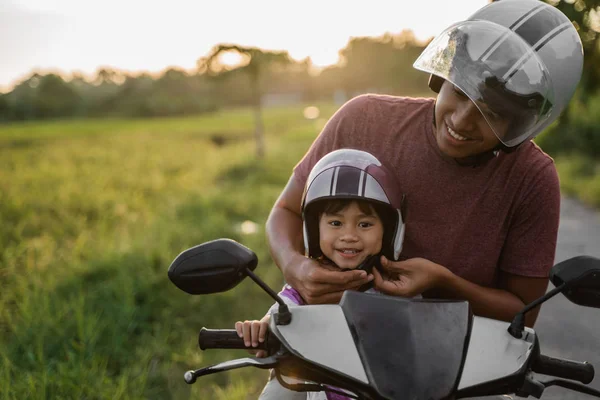 Papa aider sa fille à attacher le casque — Photo