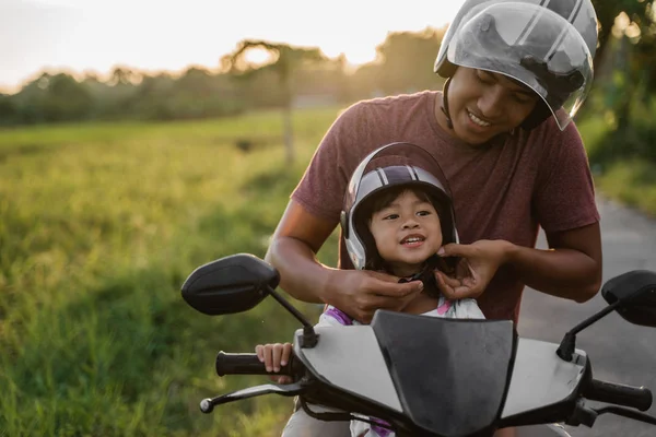 Papà aiutare la figlia a fissare il casco — Foto Stock