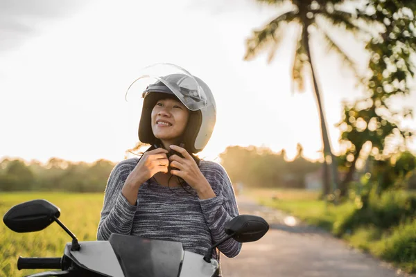 Frau trägt und befestigt ihren Helm während der Fahrt — Stockfoto