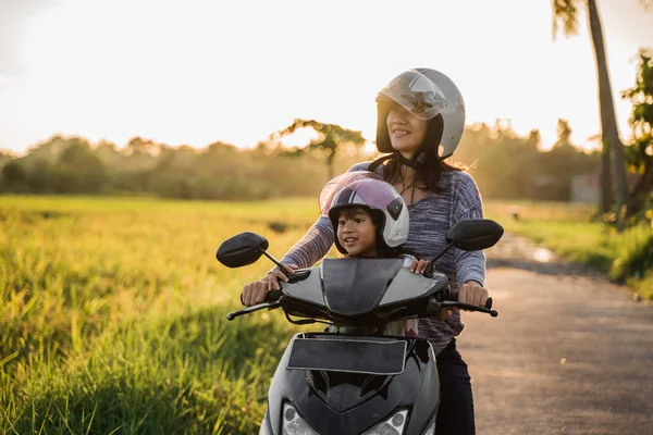 Мама и ребенок наслаждаются ездой на мотоцикле скутер — стоковое фото