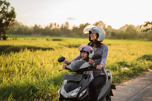 Мама и ребенок наслаждаются ездой на мотоцикле скутер — стоковое фото