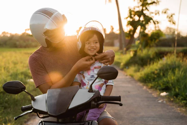 Baba kask tutturmak için kızı yardım