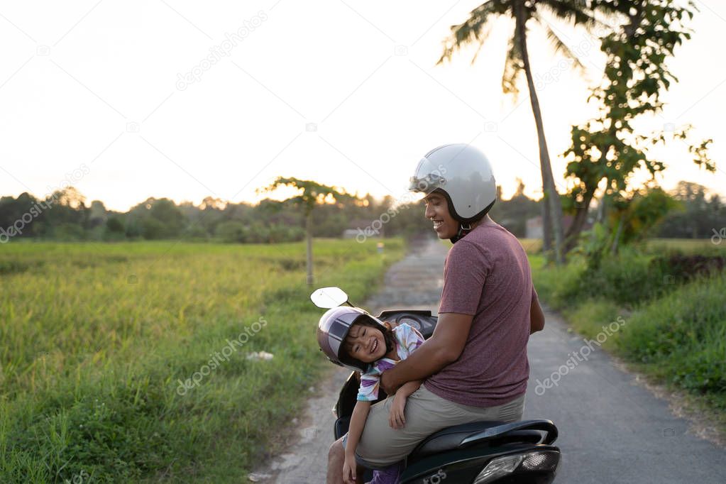 fahter and his child enjoy riding motorcycle scooter
