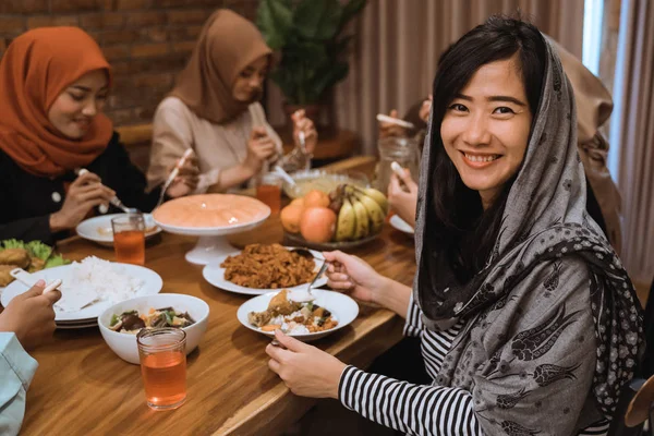 Muzułmańska kobieta uśmiechnięta podczas kolacji — Zdjęcie stockowe
