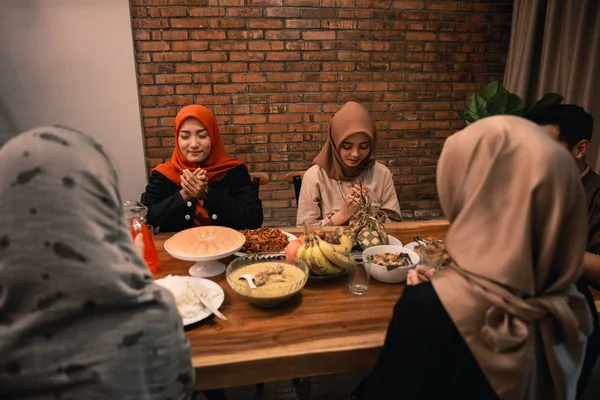 Muslim people praying before break fasting dinner — Stock Photo, Image