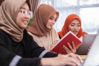 dizüstü bilgisayar kullanarak birlikte tartışan öğrenci