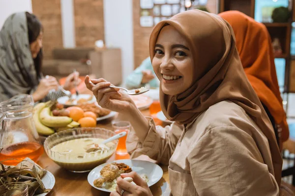 Mulher muçulmana sorrindo enquanto jantar — Fotografia de Stock