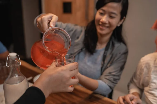 Женщина наливает немного сока в стакан — стоковое фото