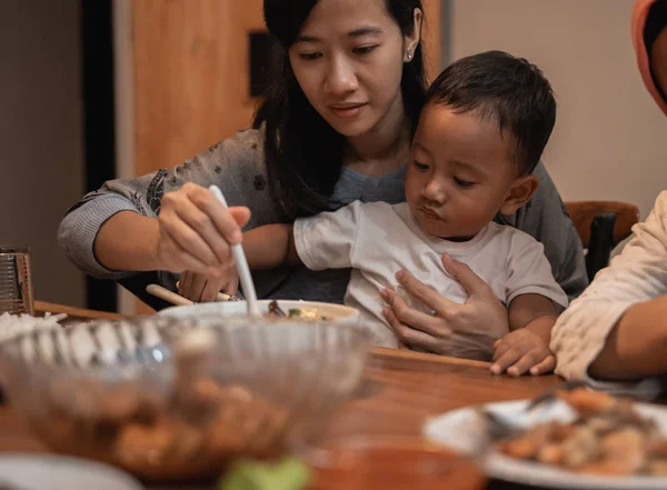 Ibu dengan anaknya makan bersama saat makan malam — Stok Foto