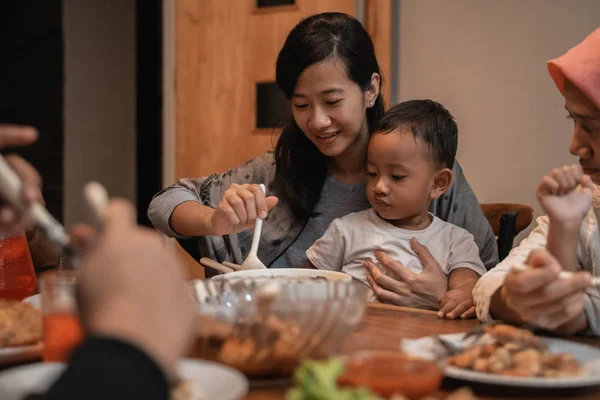 Ibu dengan anaknya makan bersama saat makan malam — Stok Foto