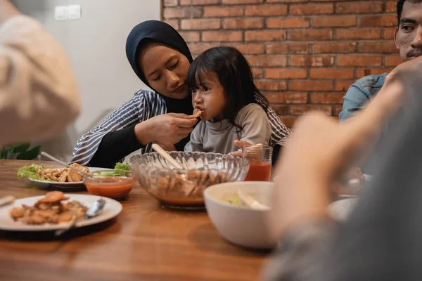 Ibu muslim memberi makan anaknya saat makan malam — Stok Foto