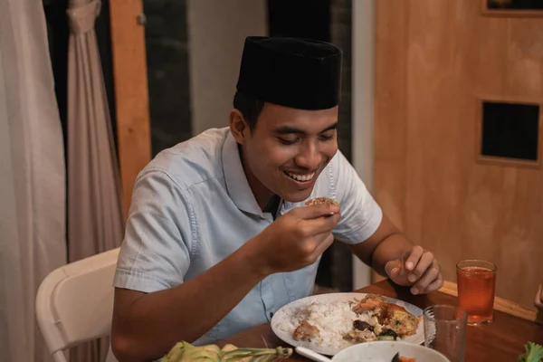 Nuori muslimimies syö illallista perheen kanssa — kuvapankkivalokuva