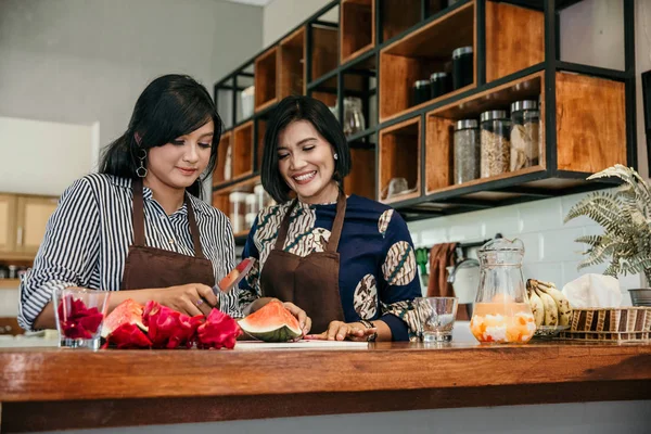 Mãe feliz e filha fazendo coquetel de frutas — Fotografia de Stock