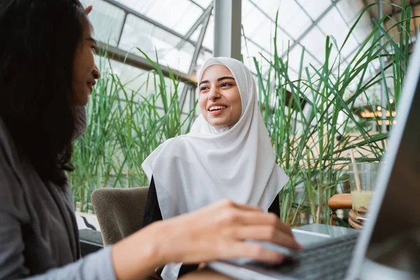 Muslimsk kvinna och vän diskuterar med laptop — Stockfoto