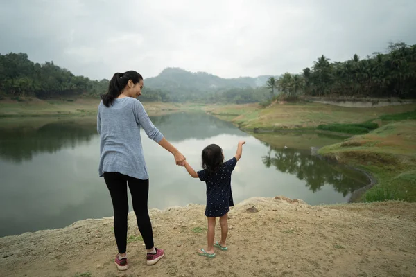 Mãe com sua criança na vista para o lago ao ar livre — Fotografia de Stock