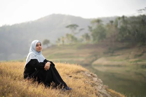 Žena s hidžáb sedí venku — Stock fotografie