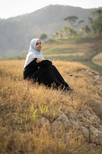Женщина с хиджабом сидит на открытом воздухе — стоковое фото