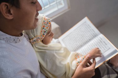 Müslüman baba kızıyla birlikte Kuran okudu.