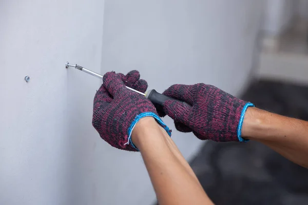 Руки с перчатками с помощью отвертки — стоковое фото