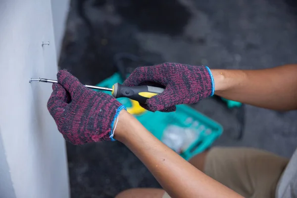 Hände mit Handschuhen mit Schraubenzieher — Stockfoto