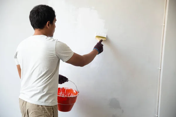 Uomo usando pennello per ridipingere — Foto Stock