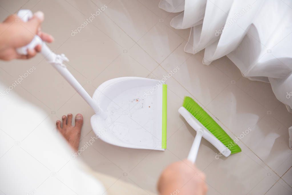 housekeeper is sweeping the floor
