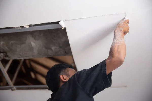 Άνθρωπος επισκευάσει το σπασμένο ταβάνι — Φωτογραφία Αρχείου