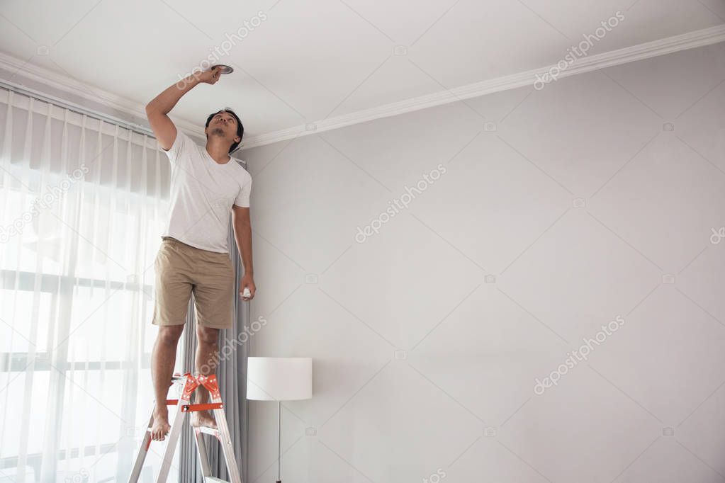 man using a stairs to install lights