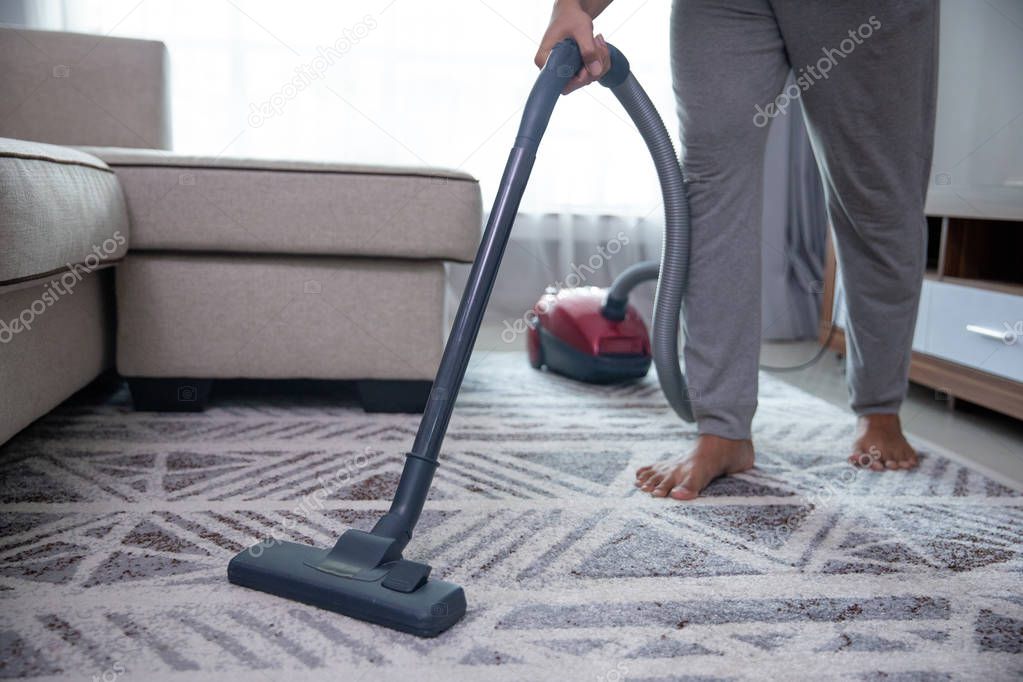 man hand vacuuming carpet 