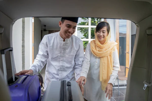 穆斯林亚洲夫妇把手提箱在汽车后备箱 — 图库照片