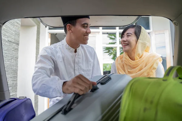 Pasangan muslim asia menaruh koper di bagasi mobil — Stok Foto