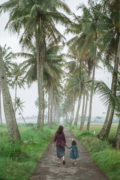 Moeder en dochter lopen in Coconut Country Road — Stockfoto