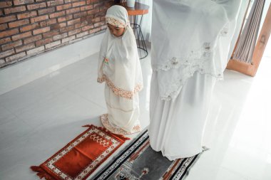 müslüman asyalı anne ve kızı dua 