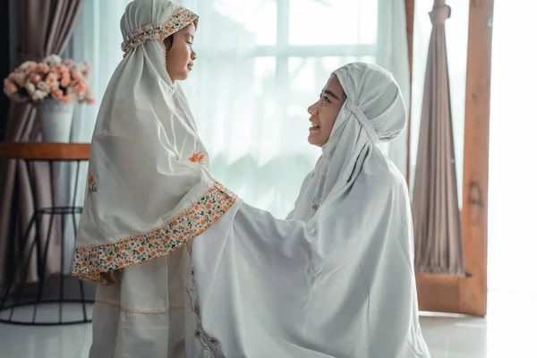muslim mother and child with scarf to pray