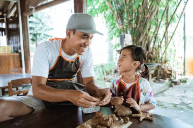 asya baba ve kızı kil ile çalışan