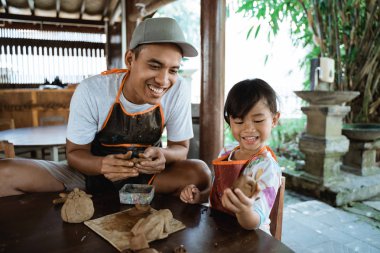 asya baba ve kızı kil ile çalışan