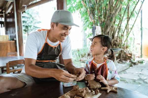 asya baba ve kızı kil ile çalışan