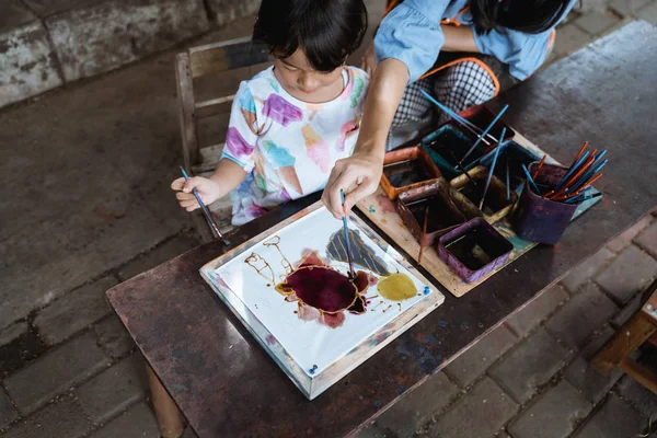 Mãe e criança asiático fazendo batik padrão — Fotografia de Stock