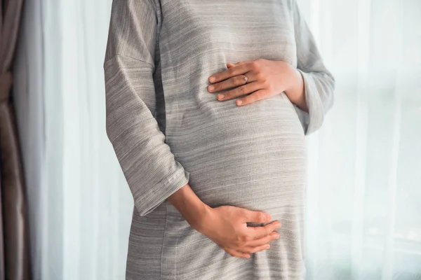 Mão segurar na barriga grávida sobre branco — Fotografia de Stock