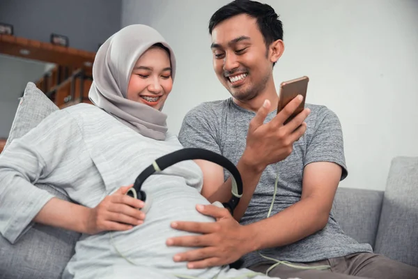 Wanita hamil dengan headphone di perutnya — Stok Foto