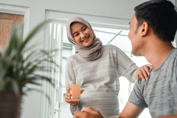 アジアのイスラム教徒の女性は、彼女の夫にいくつかの飲み物を提供しています — ストック写真